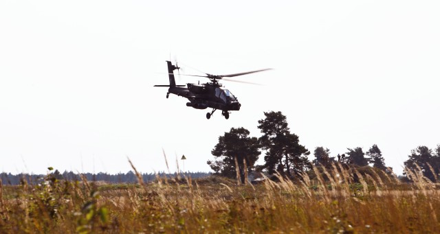 AH -64 Apache helicopter from the U.S. 1-101st Combat Aviation Brigade flies over the engagement area during the Wojtek Fire Exercise.