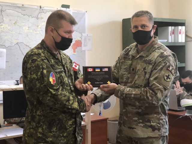 Lt. Col. Darren Horton, Task Force Illini Operations Group Officer in Charge presents a plaque to Canadian Capt. Jeremy Remillard, Sept. 15, recognizing him for exceptional support to the Operations Group. (U.S. Army photo)