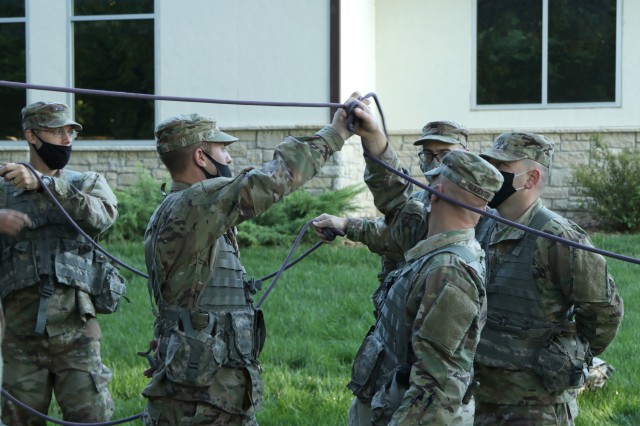 Officer Candidate School candidates of class 65 rely on one another as they untangle themselves during a teamwork and communication activity at the Webster Conference Center in Salina, Kansas, September 13, 2020. “You can’t do it alone,”...