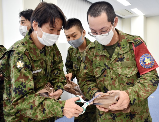 Japan Ground Self-Defense Force members prepare to eat U.S. Meals, Ready-to-Eat during the Japan Ground Self-Defense Force Reserve Interpreters Training symposium at Camp Zama, Japan, Sept. 24.
