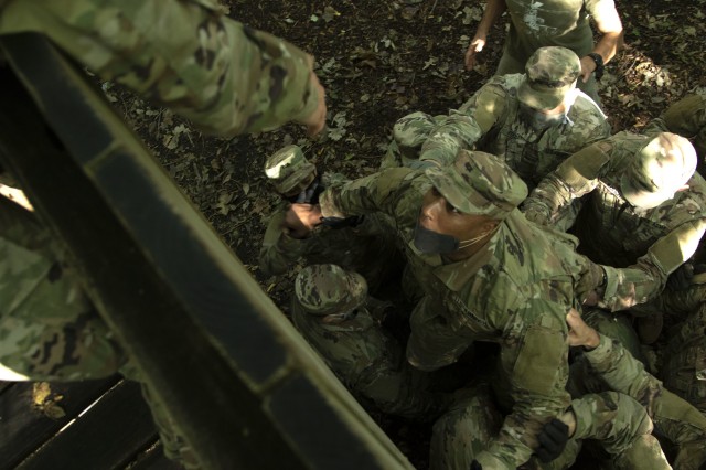 Officer Candidate School candidates of class 65 help each other over a high wall obstacle testing their teamwork and communications skills at the Webster Conference Center in Salina, Kansas, Sept. 13, 2020. “We are looking for the candidates to...