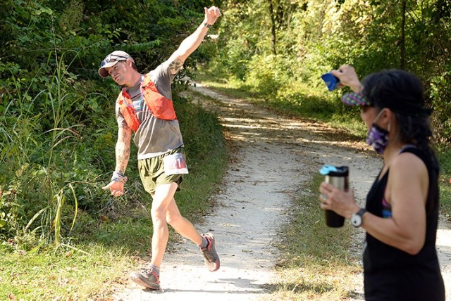 Race participant Mark Kramer rounds a turn along the 1908 Ultra Challenge trail run route as event organizer Col. Angel Liberg, Combined Arms Center Army Reserve Affairs assistant chief of staff, rattles a cowbell near completion of the first 4.5-mile loop of the 19-hour run Sept. 26 near Camp Conestoga. The event was 19 hours and eight minutes long -- 1908 was the year the U.S. Army Reserve was federally recognized. Photo by Prudence Siebert/Fort Leavenworth Lamp