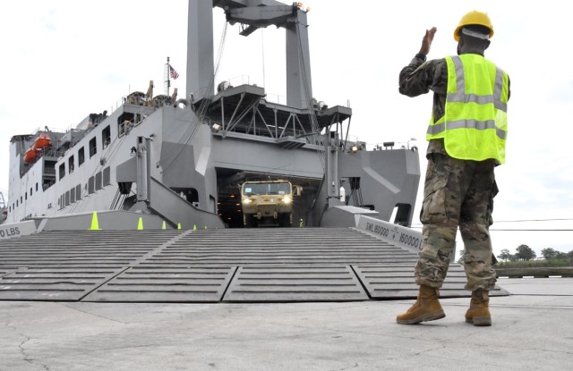 A Soldier with 7th Transportation Brigade gives hand signals to a Soldier offloading a vehicle at Port Arthur, Texas, Sept. 25 as part of Joint Readiness Exercise 20. The vehicle will be used by the 2nd BCT, 25th Inf Div during JRTC Rotation 21-01.