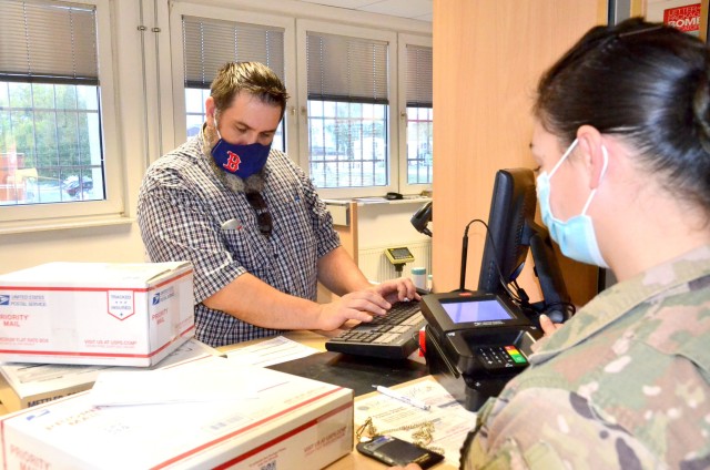 A Soldier mails several packages to the United States from the Rhine Ordnance Barracks Postal Services Center in Kaiserslautern, Germany recently. Postmasters are urging customers to mail holiday packages earlier than usual due to the COVID-19...