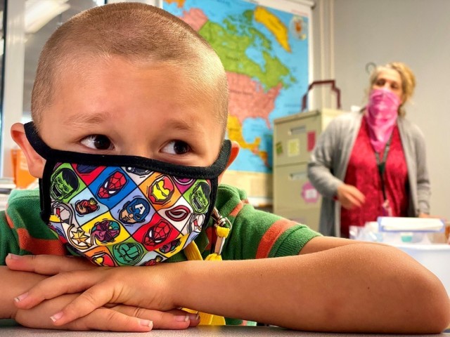 Sporting an Avengers coronavirus mask, Liam Hall waits for his second grade class to begin at Patch Elementary School, at Panzer Kaserne in Böblingen, Germany.