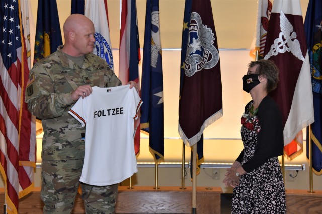 Col. Bradley Ladd presents a customized Baltimore Orioles jersey to Linda Foltz during her retirement ceremony on Sept. 30 at Fort Detrick, Maryland. Foltz, an avid Orioles fan, retired after 46 years as a civilian employee with the U.S. Army Medical Materiel Agency.
