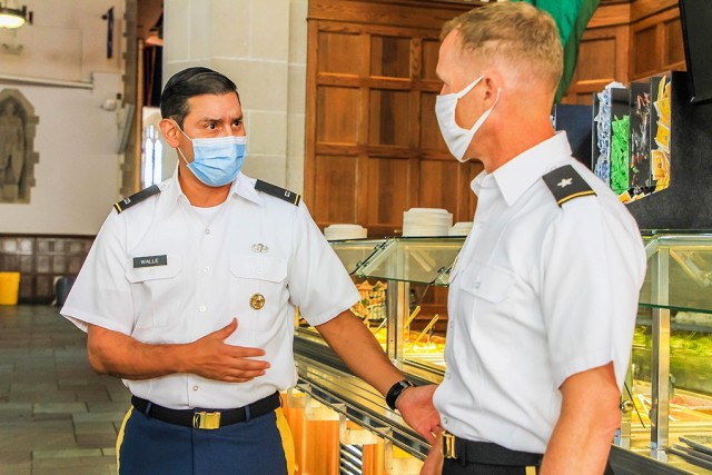 Chief Warrant Officer 4 Edgar Walle, the installation food advisor (left), explains the healthier options for cadets in the new menu to Brig. Gen. Curtis Buzzard, Commandant of Cadets. Through the Go For Green program, Walle changed the entire menu to implement healthier food options and discard all fried foods.