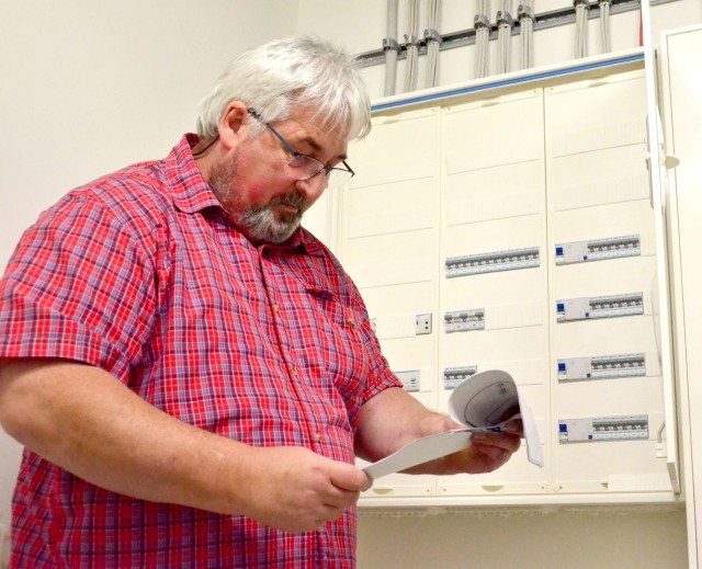 Herb Nold, USAG Rheinland-Pfalz Installation Safety Office inspector, checks the schematics and labeling on a breaker box in a garrison building recently.