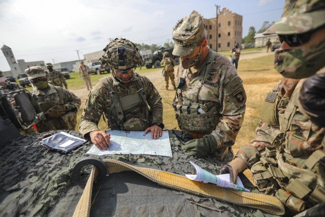 Col. Robert Born, commander of 1st Brigade Combat Team, 101st Airborne Division (Air Assault), briefs Maj. Gen. Brian E. Winski, commanding general of the 101st Abn. Div. and Fort Campbell, on his defensive plan via a map on the hood of a humvee...