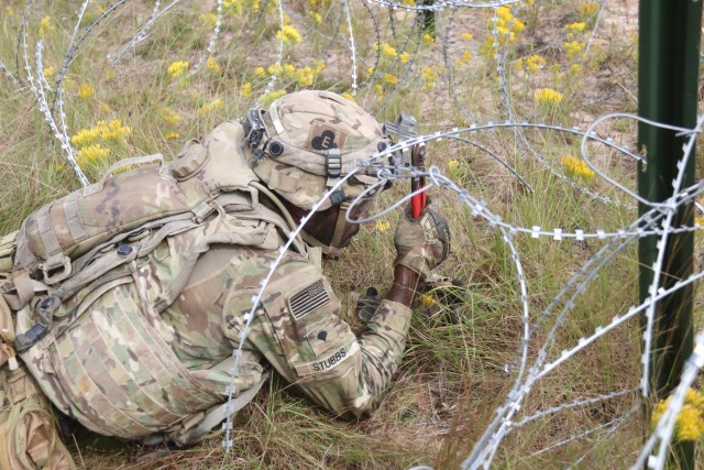 Spc. Cyril Stubbs, combat engineer, A. Co., 326th Brigade Engineer Battalion, 1st Brigade Combat Team, 101st Airborne Division (Air Assault), manually breaches a wire obstacle Sept. 27, during the live fire exercise at Joint Readiness Training...
