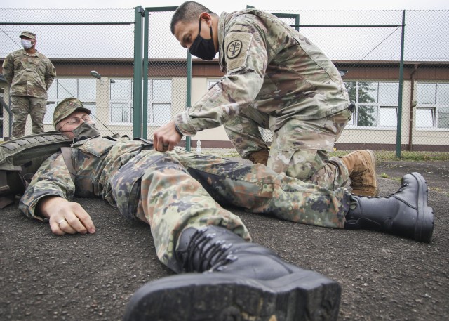 U.S. Army Staff Sgt. Noel Ang, an instructor with the International Trauma Combat Casualty Care course at Landstuhl Regional Medical Center, checks a self-applied tourniquet on a Bundeswehr (German Armed Forces) Soldier, Sept. 30. The...