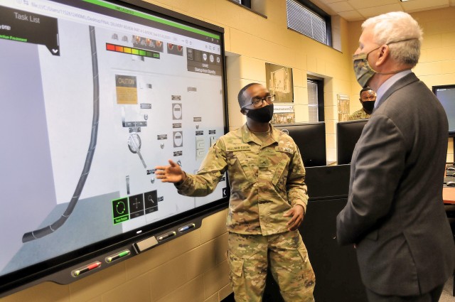 Advanced individual training student Pvt. Xavier Sullivan-Dixon explains the workings of a water treatment system to The Honorable James McPherson, Undersecretary of the Army, during the Undersecretary’s visit to the Quartermaster School’s Petroleum and Water Department. Sullivan-Dixon and two of his fellow students walked the undersecretary through a virtual training program now being used by the schoolhouse.