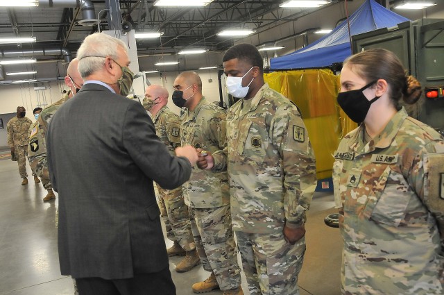 The Honorable James McPherson, Under Secretary of the Army, presents a coin to Sgt. 1st Class Dedric Daniels, an instructor, during his visit to the Ordnance School Oct. 7. McPherson visited several training facilities and talked with leaders and Soldiers during a daylong visit to the installation.