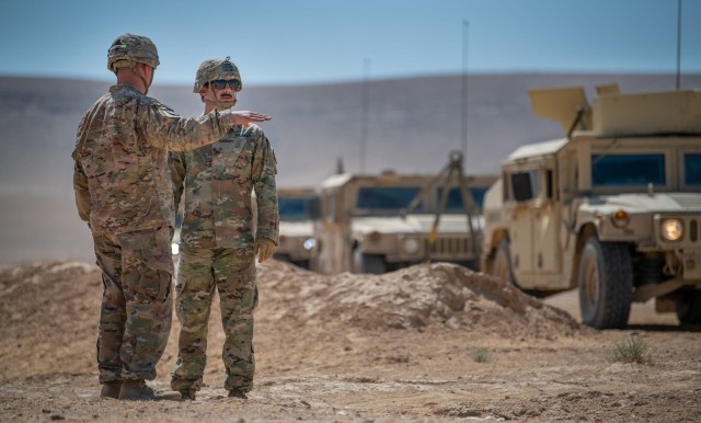 Staff Sgt. Dakota Montgomery, left, training NCO with HHB, 75th FA Brigade, describes the convoy route to Sgt. Gage McLaughlin before the Soldiers head out on their dusty  excursion.