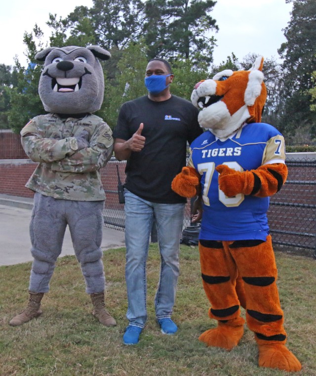 Rocky, the 3rd Infantry Division mascot, Roland Vanhorn, Bradwell Institute principal, and the Bradwell Institute Tigers mascot, pose for a photo before a military appreciation game between Bradwell Institute and Richmond Hill High School Oct. 9,...