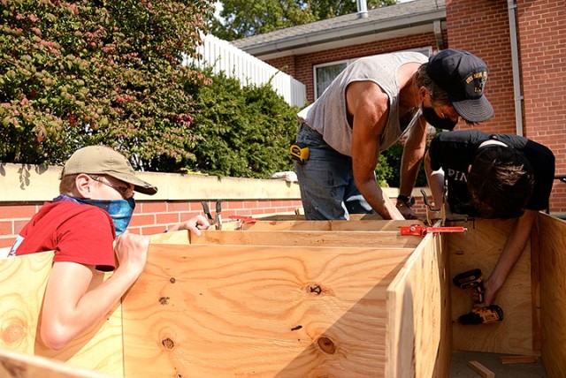 Scouts BSA Troop 366 member Aiden Harris holds a board in place as adult volunteer Darryl Ragsdale and Troop 165 member John Goodman work on another section of a blessing box, Troop 166 member Carey Nestler's Eagle Scout project, Oct. 10 outside...