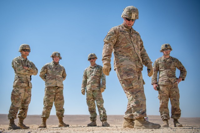 Staff Sgt. Dakota Montgomery, training NCO assigned to HHB, 75th FA Brigade, creates a makeshift sandbox detailing the planned route prior to unit convoy training.