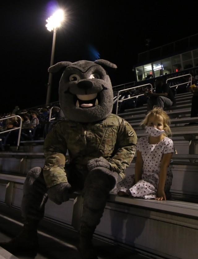 Rocky, the 3rd Infantry Division mascot, sits with Elizabeth Black, 5, during a military appreciation game between Bradwell Institute and Richmond Hill High School Oct. 9, 2020, at Olvey Field, Hinesville, Georgia. Elizabeth, along with her mom...