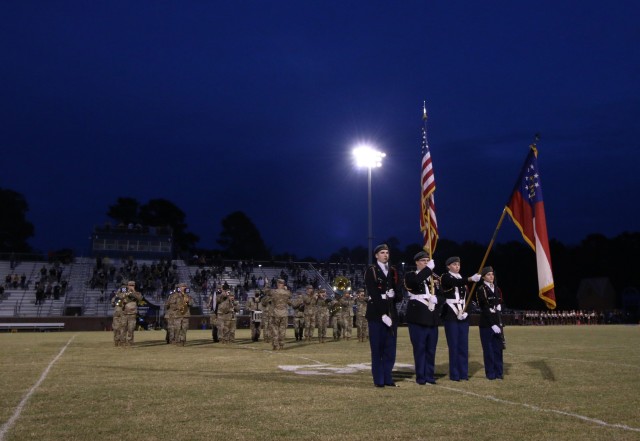 Members of the Bradwell Institute Junior Reserve Officers’ Training Corps serve as the color guard as the 3rd Infantry Division plays the national anthem before a military appreciation game between Bradwell Institute and Richmond Hill High...