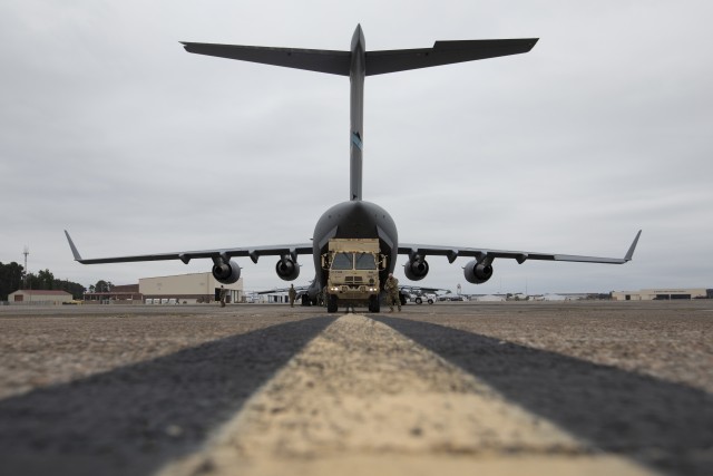 U.S. Army Soldiers from the 3rd Combat Aviation Brigade, 3rd Infantry Division, prepare to load a medium tactical vehicle onto a C-17 Globemaster aircraft during joint air load training at Hunter Army Airfield, Georgia, Oct. 6. This training is...