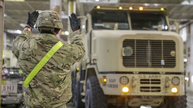 U.S. Army Soldier assigned to 1st Cavalry Division Sustainment Brigade guides one of the first vehicles off the Sea-Vessel (Integrity) in Antwerp, Belgium on Feb 25, 2020. The equipment that is coming off the Integrity will be apart of the large...