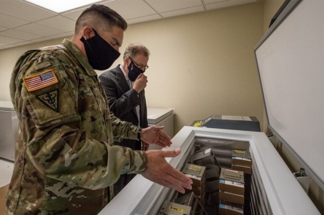 Maj. Juan Guzman, chief of the Armed Services Blood Bank Center-Pacific Northwest, shows Assistant Secretary of Defense for Health Affairs Thomas McCaffery where the center stores the convalescent plasma it collects from donors who have recovered...