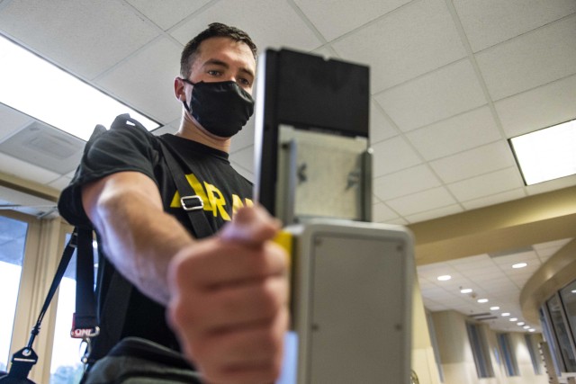 A U.S. Army Soldier scans his wrist and face at a terminal newly installed to screen for high temperatures of people entering Marshall Hall, the U.S. Army Reserve Command and U.S. Forces Command headquarters building at Fort Bragg, N.C., Sept. 29, 2020. The terminal is expected to reduce and eventually eliminate the required staffing of Soldiers who currently screen people&#39;s temperatures coming into the building. The terminal scans body temperatures via the wrist to eliminate contact and stores up to 10,000 face images, which can help with contact tracing if someone is later found to test positive for COVID-19. 