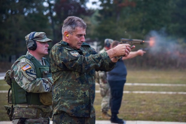 Bulgarian Chief of Defense Adm. Emil Eftimov fires the M-17 handgun, Oct. 8, at a small-arms pop-up range at Volunteer Training Site - Tullahoma. Bulgarian officials visited the Tennessee National Guard after signing a new training roadmap with the U.S., renewing their partnership through 2030.