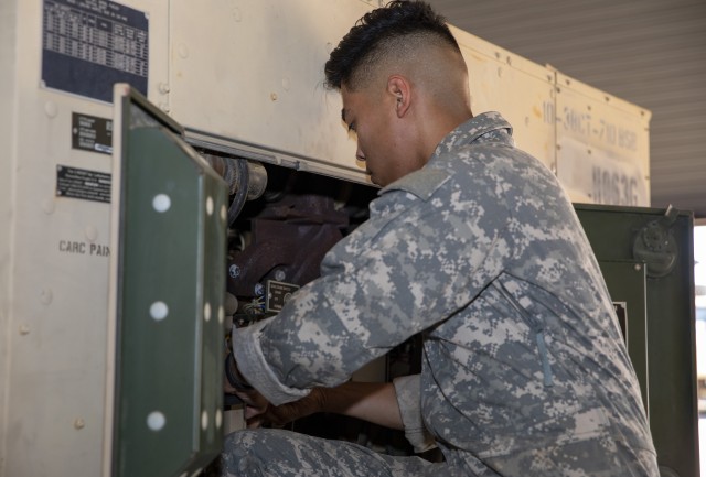 U.S. Army Spc. Seigfred R. Velarde, a tactical power generation specialist with Bravo Company, 710th Brigade Support Battalion, 3rd Brigade Combat Team 10th Mountain Division, repairs a 30,000-watt diesel engine generator set, inside the work bay...