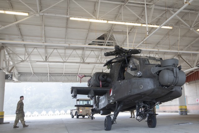 U.S. Army Soldiers from the 3rd Combat Aviation Brigade, 3rd Infantry Division, prepare to weigh an AH-64 Apache helicopter while conducting air load training with the Airmen from the 621st Mobility Support Operations Squadron, Oct. 7, at Hunter...
