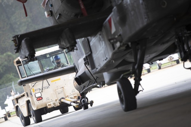 A U.S. Army Soldier assigned to the 3rd Combat Aviation Brigade, 3rd Infantry Division, moves a AH-64 Apache helicopter to be weighed while conducting air load training with the Airmen from the 621st Mobility Support Operations Squadron, Oct. 7, at Hunter Army Airfield, Georgia. This training is vital to ensuring the joint forces are ready to safely and efficiently load equipment onto Air Mobility Command aircraft, ensuring rapid global mobility and combat power projection. (U.S. Army photo by Sgt. Andrew McNeil 3rd Combat Aviation Brigade, 3rd Infantry Division)