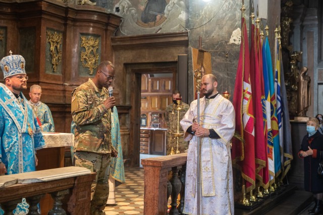 Chaplain (Maj.) Vincent Lambert offers a prayer to a large congregation gathered at the Saints Peter and Paul Garrison Church during a Defender’s Day memorial service, Oct. 14. (Photo by U.S. Army Cpl. Shaylin Quaid, JMTG-U Public Affairs)