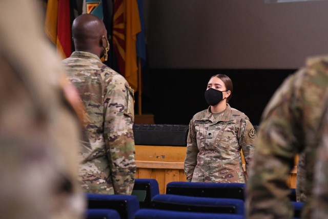 US Army Spc.  Sarah Courtney, assigned to Troop Headquarters, 4th Squadron, 2nd Cavalry Regiment, leads a class of graduates from the 7th Army Training Command's NCO Academy 'Basic Leadership Course in a recitation of the NCO's Creed at Rose Barracks Theater in Vilseck, Germany, October 9, 2020. Due to COVID-19 restrictions, the course and graduation took place both in person and virtually, the majority of graduates participating virtually.  (U.S. Army photo by Kevin Sterling Payne)