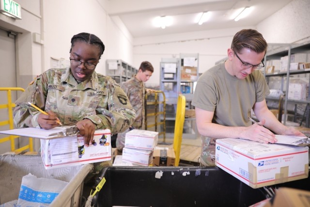 U.S. Army Soldiers assigned to the 101st Combat Aviation Brigade, 101st Airborne Division (Air Assault) Spc. Jazmine Reed and Pvt. 1st Class Michael Hardwood sort new packages while Spc. Joshua Saenz organizes shelves for mail to be issued the...