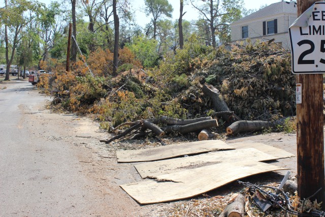 Large piles of vegetative debris line the streets of Cedar Rapids, Iowa, following an intense, fast-moving wind storm, called a derecho, caused widespread damage across the state.