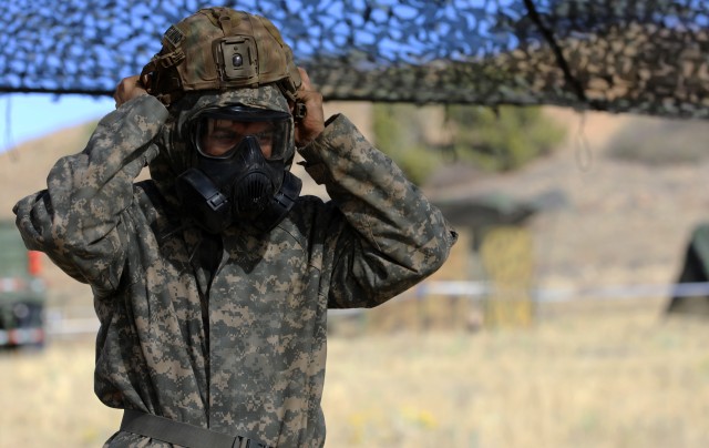 A Soldier with 4th Infantry Division practices donning Mission Oriented Protective Level IV as part of the chemical, biological, radiological and nuclear task in the patrol lane during the Expert Infantryman Badge and Expert Soldier Badge testing week, Oct. 14 at Fort Carson, Colo. The EIB and ESB is awarded to infantrymen and Soldiers, respectively, for demonstrating their competence and readiness as infantrymen and Soldiers. (U.S. Army photo by Sgt. Gabrielle Pena)