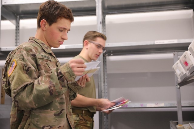 U.S. Army Soldiers Spc. Joshua Saenz and Pvt. 1st Class Michael Hardwood from the 101st Combat Aviation Brigade, 101st Airborne Division (Air Assault) sort incoming mail at the Storck Barracks Army Post Office in Illeshiem, Germany, Oct. 9, 2020....