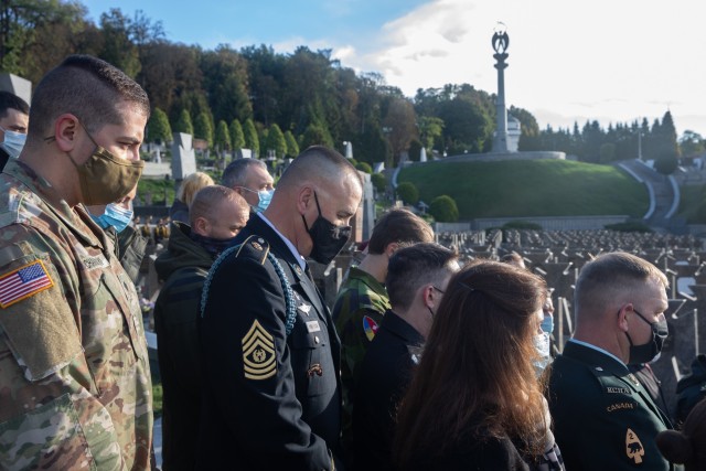 Spc. Vitalii Anchakivskyi and Command Sgt. Maj. Douglas Danielson bow their heads in prayer alongside other multinational partners during the Defender’s Day memorial ceremony at the historical Lychakiv Cemetery in Lviv, Ukraine, Oct. 14. (Photo...