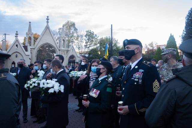 Command Sgt. Maj. Douglas Danielson holds a candle votive as he waits among a crowd to place it during a Defender’s Day memorial ceremony at the historical Lychakiv Cemetery in Lviv, Ukraine, Oct. 14. (Photo by U.S. Army Cpl. Shaylin Quaid,...