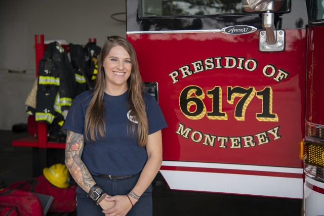 Presidio of Monterey Firefighter/EMT Andrea Kiser poses in front of a fire engine at the Ord Military Community fire station. 