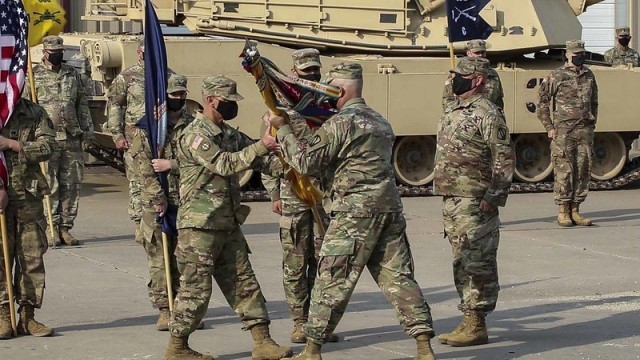 Sgt. Maj. Lee Girard, left, incoming command sergeant major of the new 1st Battalion, 635th Armor Regiment, accepts the regimental colors from Lt. Col. Rodney Seaba, right, commander of the 1st Bn., 635th Armor Regt., and relieves outgoing command sergeant major, Command Sgt. Maj. Paul Purdham, from his responsibilities during a virtual change of responsibility ceremony Oct. 17. The change of responsibility ceremony was held in conjunction with the redesignation ceremony of the 2nd Combined Arms Battalion, 137th Infantry Regiment “First Kansas” as the 1st Bn., 635th Armor Regt. in accordance with a 2012 Army Chief of Staff directive.