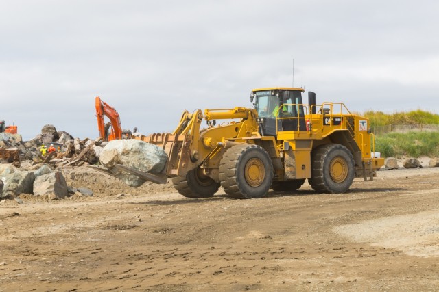 A construction crewmember moves a stone so excavators can place it on the South Jetty near Hammond, Ore., Aug. 31. The Portland District, U.S. Army Corps of Engineers has been rehabbing the jetty system for the last several years (completing work...