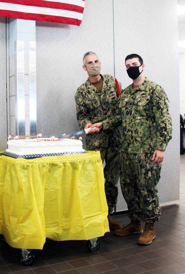 Senior Chief Petty Officer Przemek Krysinski and Petty Officer 2nd Class Matthew Snow, the oldest and youngest Sailors present, make the first cut to the Navy birthday cake during a celebration Oct. 13, 2020, at a Fort McCoy, Wis., dining...