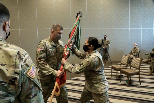 KADENA AIR FORCE BASE, Japan – Interim Command Sgt. Maj. Shawn T. Gulley, 1st Battalion, 1st Air Defense Artillery Regiment operations sergeant major, passes the battalion colors to Lt. Col. Rosanna Clemente, 1-1 ADA commander, signifying a...