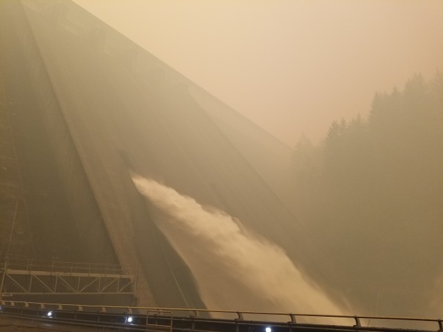 Mike Pomeroy, trapped at Detroit Dam by wildfires, took a photo of the regulating outlet as wildfires loomed in the distance.