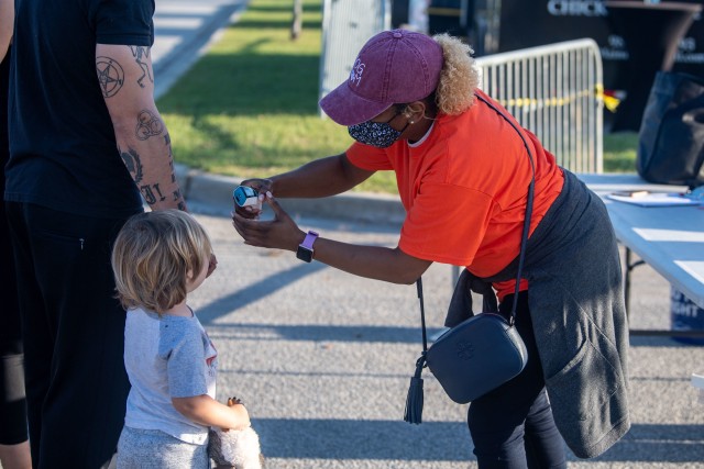 Pia Johnson, a volunteer for National Night Out, checks temperatures of guests before they can enter the event, Oct. 6.