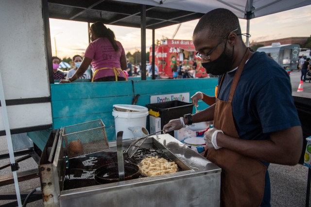 A worker makes funnel cakes at one of the food trucks during National Night Out, Oct. 6.
