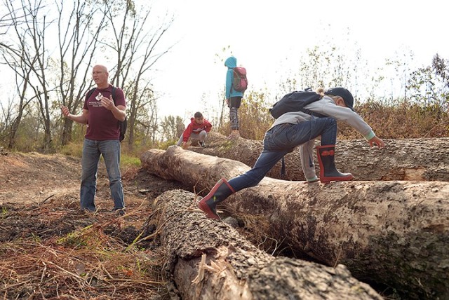 Natural Resources Specialist Neil Bass shares the possible use of a large 140-plus-year-old fallen tree of turning it into a conference table as children, including 5-year-old Clara Prokoph, climb on the logs before setting off on a Military Wild...