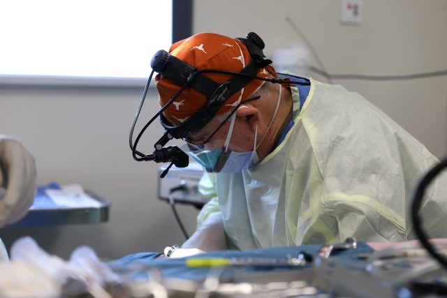 Col. (Dr.) Tom Goksel, an oral maxillofacial surgeon, removes molar teeth from a service member.