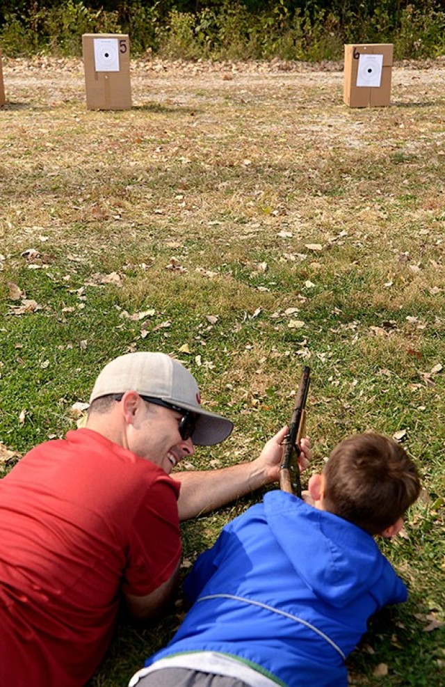 Capt. John Churchill, Command and General Staff Officer Course student, congratulates his 7-year-old son Caleb on hitting the target at the BB gun station during the Cub Scout Pack 1 Shooting Sports Day Oct. 17 at Hunt Lodge. Photo by Prudence...